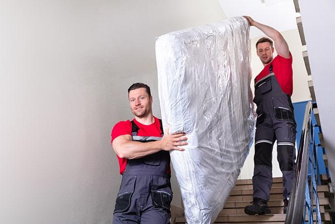 transporting a box spring out of a residential building in Highland City, FL